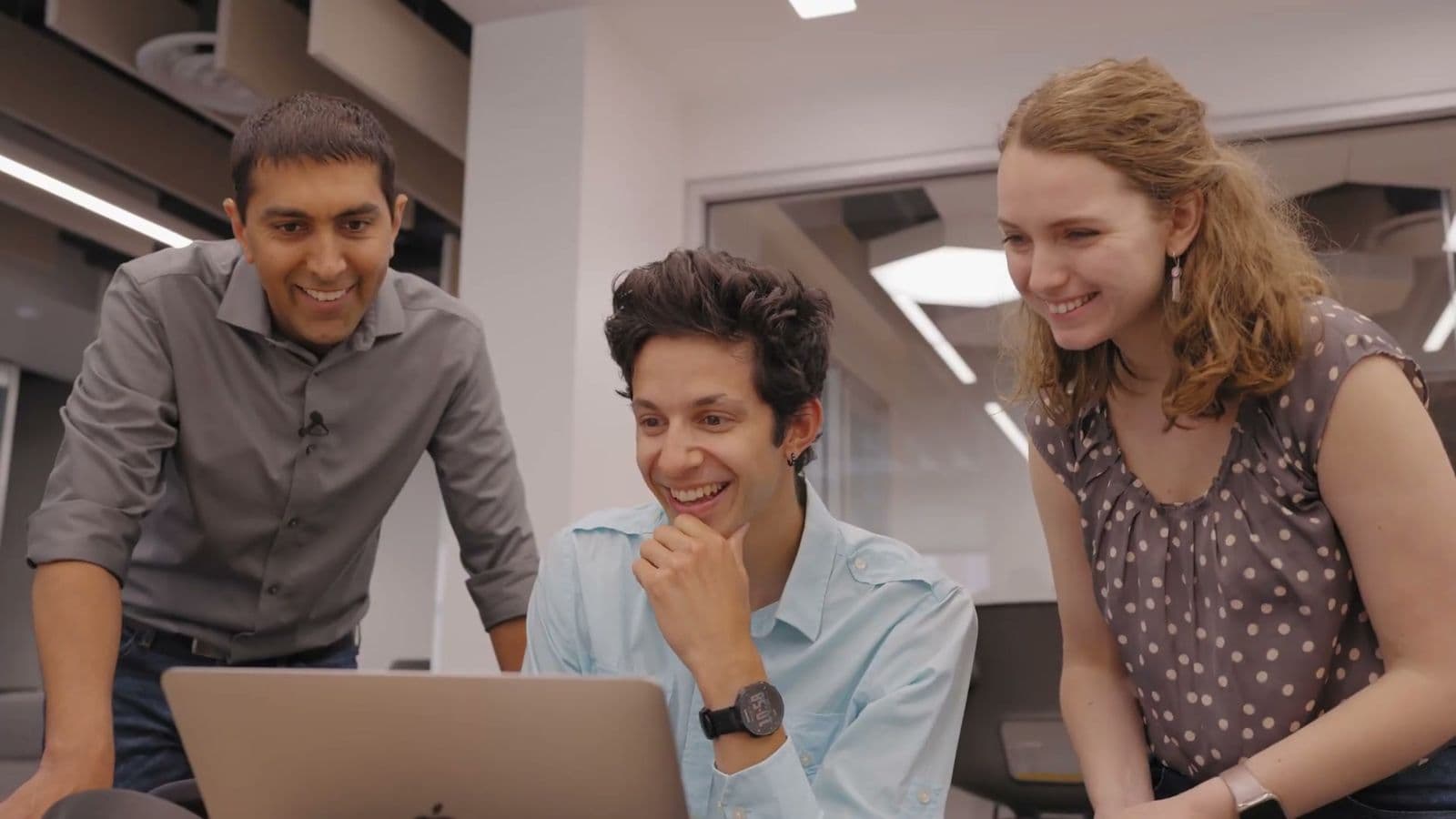 Students collaborating around a laptop